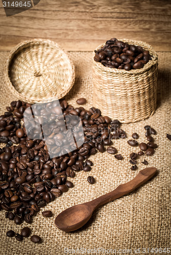 Image of pile of fresh and bio aromatic coffee beans and spoon and jar