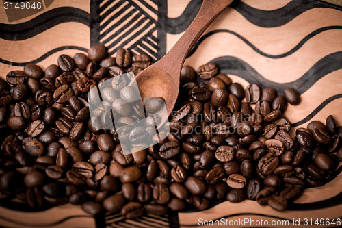 Image of pile of fresh and bio aromatic coffee beans and spoon