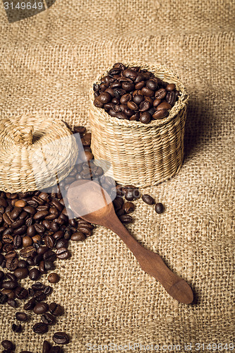 Image of pile of fresh and bio aromatic coffee beans and spoon and jar
