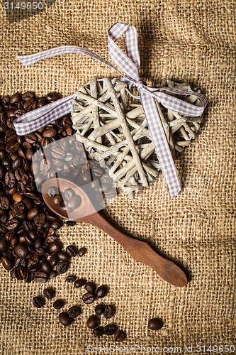 Image of pile of fresh coffee beans, heart and spoon