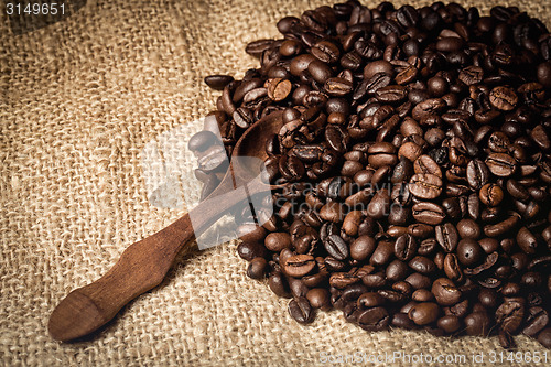 Image of pile of fresh and bio aromatic coffee beans and spoon