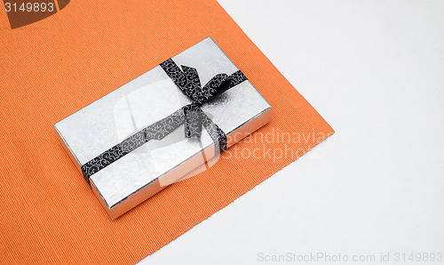 Image of silver gift box with bow on white background