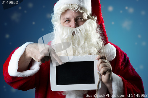 Image of Portrait Santa Claus pointing on slate