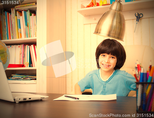 Image of smiling schoolboy doing homework