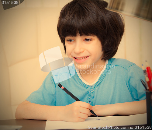 Image of smiling child doing homework with computer