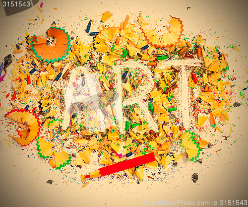 Image of art word on the background of bright colored pencil shavings