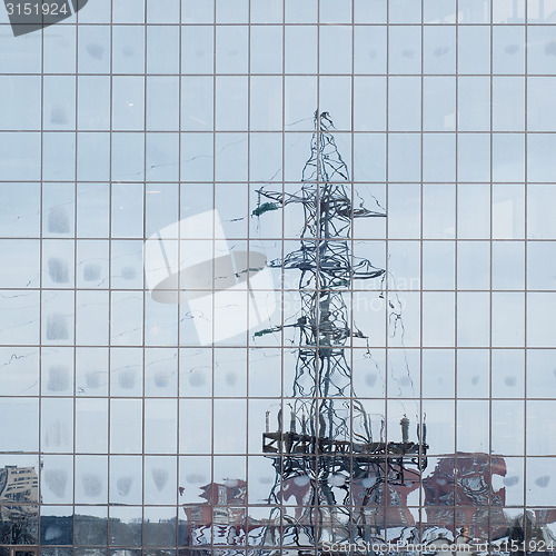 Image of electric pole reflected in windows of office building