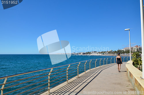 Image of Woman walking at the coastal promenade