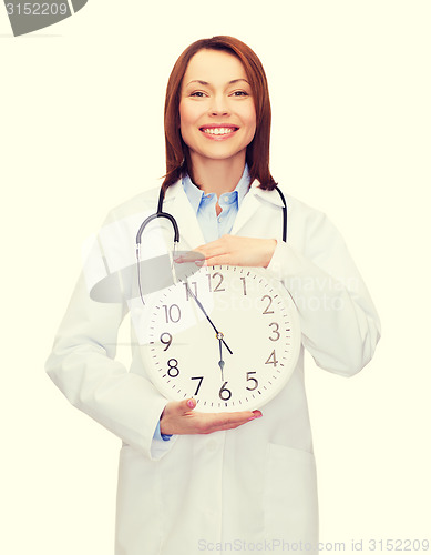 Image of smiling female doctor with wall clock