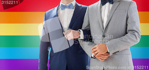 Image of close up of happy male gay couple holding hands