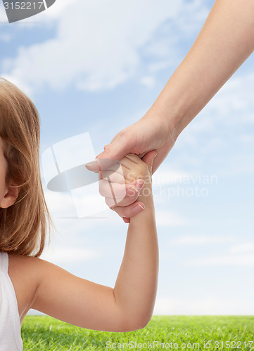 Image of close up of woman and little girl holding hands