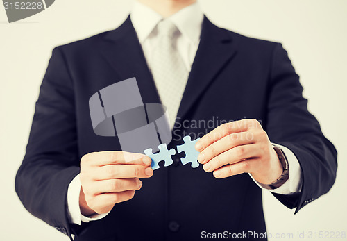 Image of man trying to connect puzzle pieces