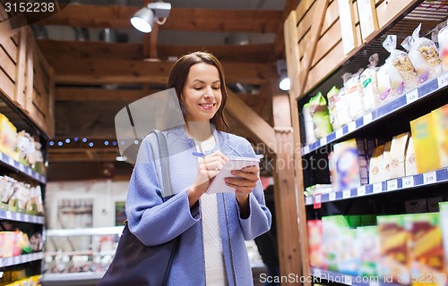 Image of happy woman with notepad in market