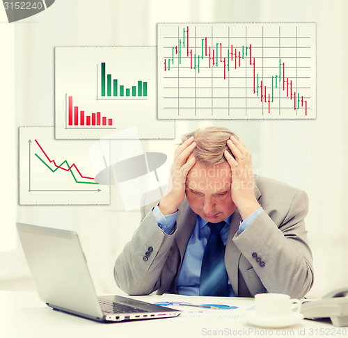 Image of upset older businessman with laptop in office