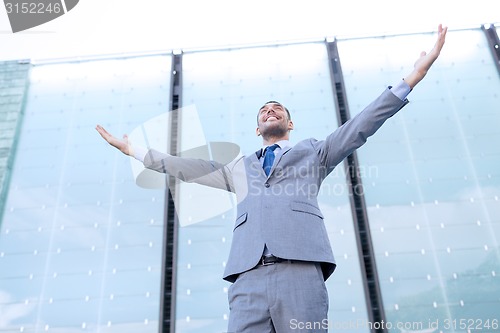 Image of young smiling businessman over office building