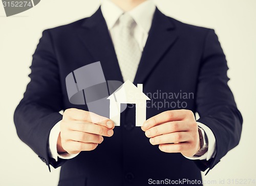 Image of man hands holding paper house