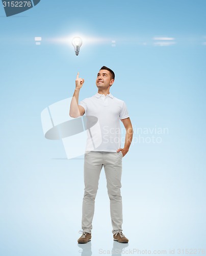 Image of smiling man pointing finger up to lighting bulb