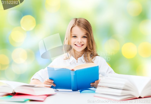 Image of happy student girl reading book at school