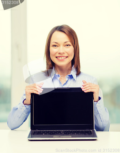 Image of businesswoman with blank black laptop screen