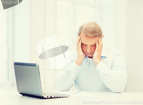 Image of stressed old man filling a form at home