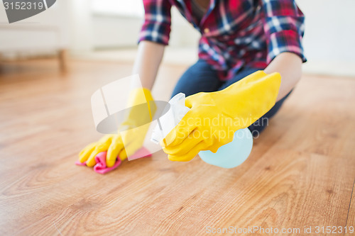 Image of close up of woman with rag cleaning floor at home