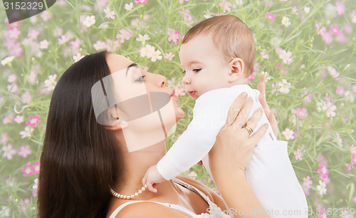 Image of happy mother kissing and holding baby