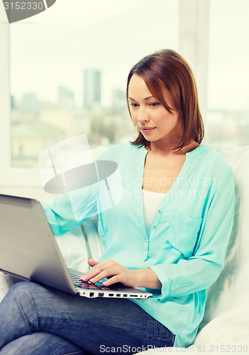 Image of happy woman with laptop at home