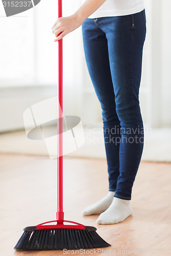 Image of close up of woman legs with broom sweeping floor