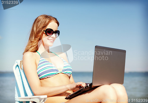 Image of girl looking at tablet pc on the beach