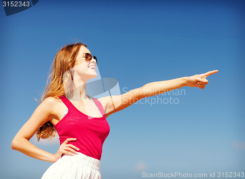 Image of girl showing direction on the beach