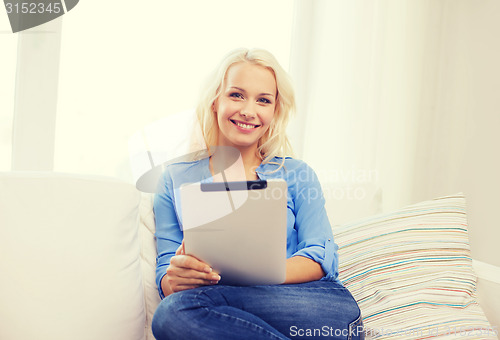 Image of smiling woman with tablet pc computer at home