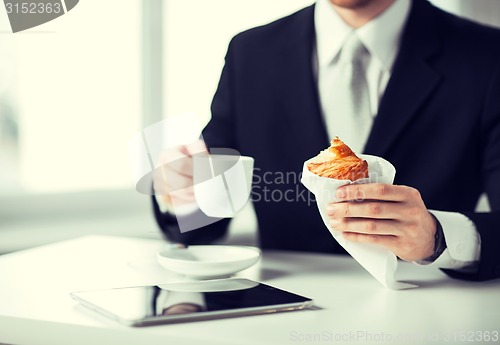 Image of man with tablet pc and cup of coffee