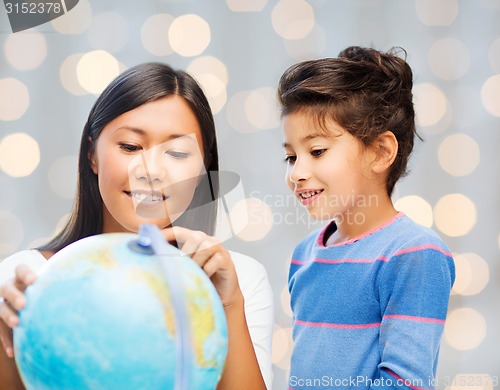 Image of happy mother and daughter with globe