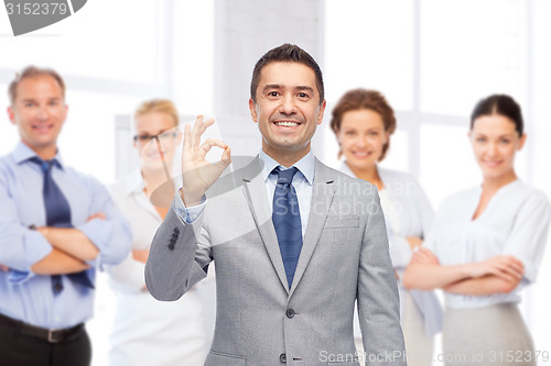 Image of happy businessman in suit showing ok hand sign