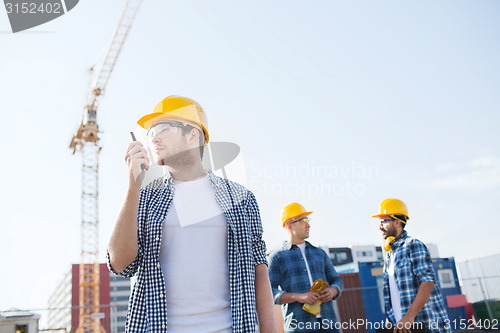 Image of group of builders in hardhats with radio