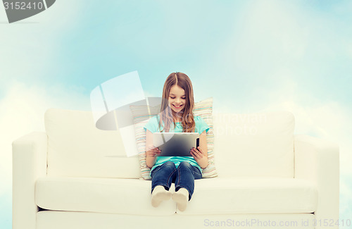Image of little girl sitting on sofa with tablet pc