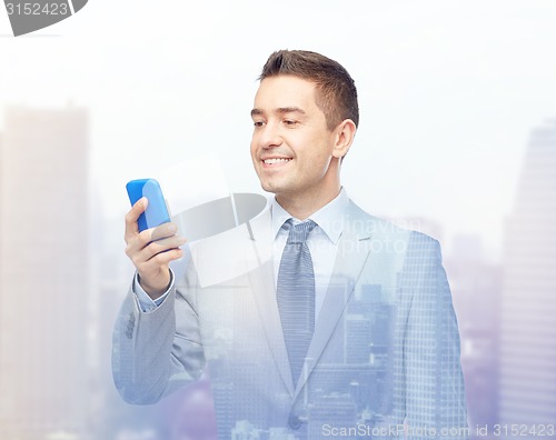 Image of happy businessman texting on smartphone