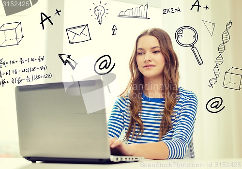 Image of smiling teenage gitl with laptop computer at home