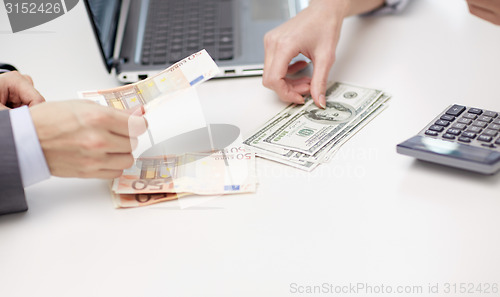 Image of close up of hands counting money at office