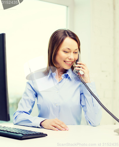 Image of businesswoman with laptop and telephone