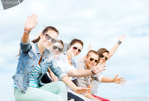 Image of group of teenagers waving hands