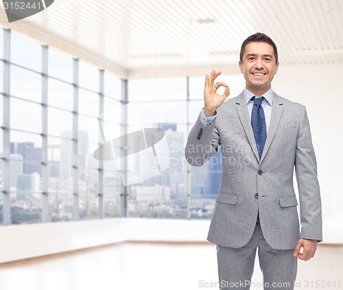 Image of happy businessman in suit showing ok hand sign