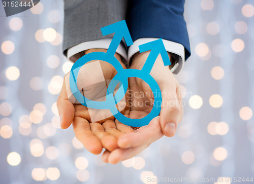 Image of close up of happy male gay couple with love symbol