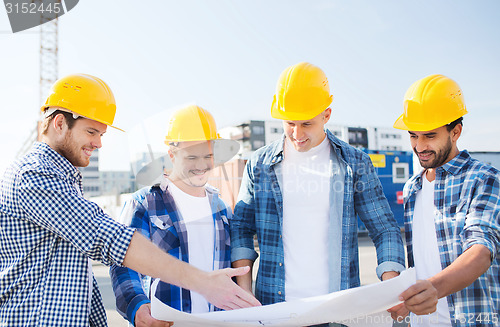 Image of group of builders with tablet pc and blueprint