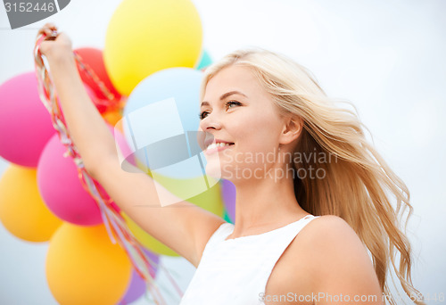 Image of woman with colorful balloons outside