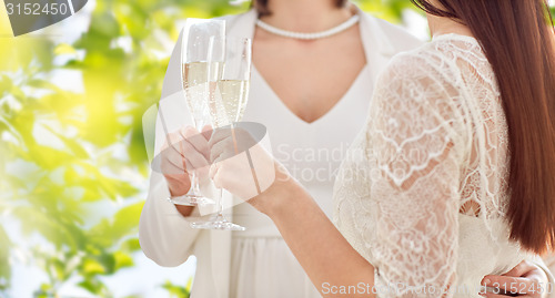 Image of close up of lesbian couple with champagne glasses