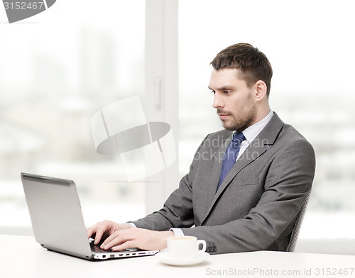 Image of busy businessman with laptop and coffee