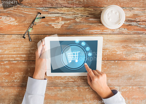 Image of close up of hands with tablet pc and shopping cart