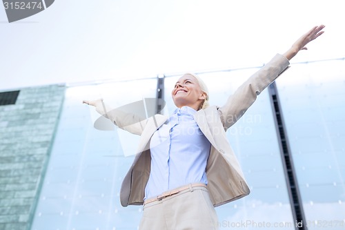 Image of young smiling businesswoman over office building