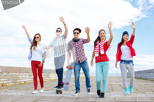 Image of group of smiling teenagers waving hands